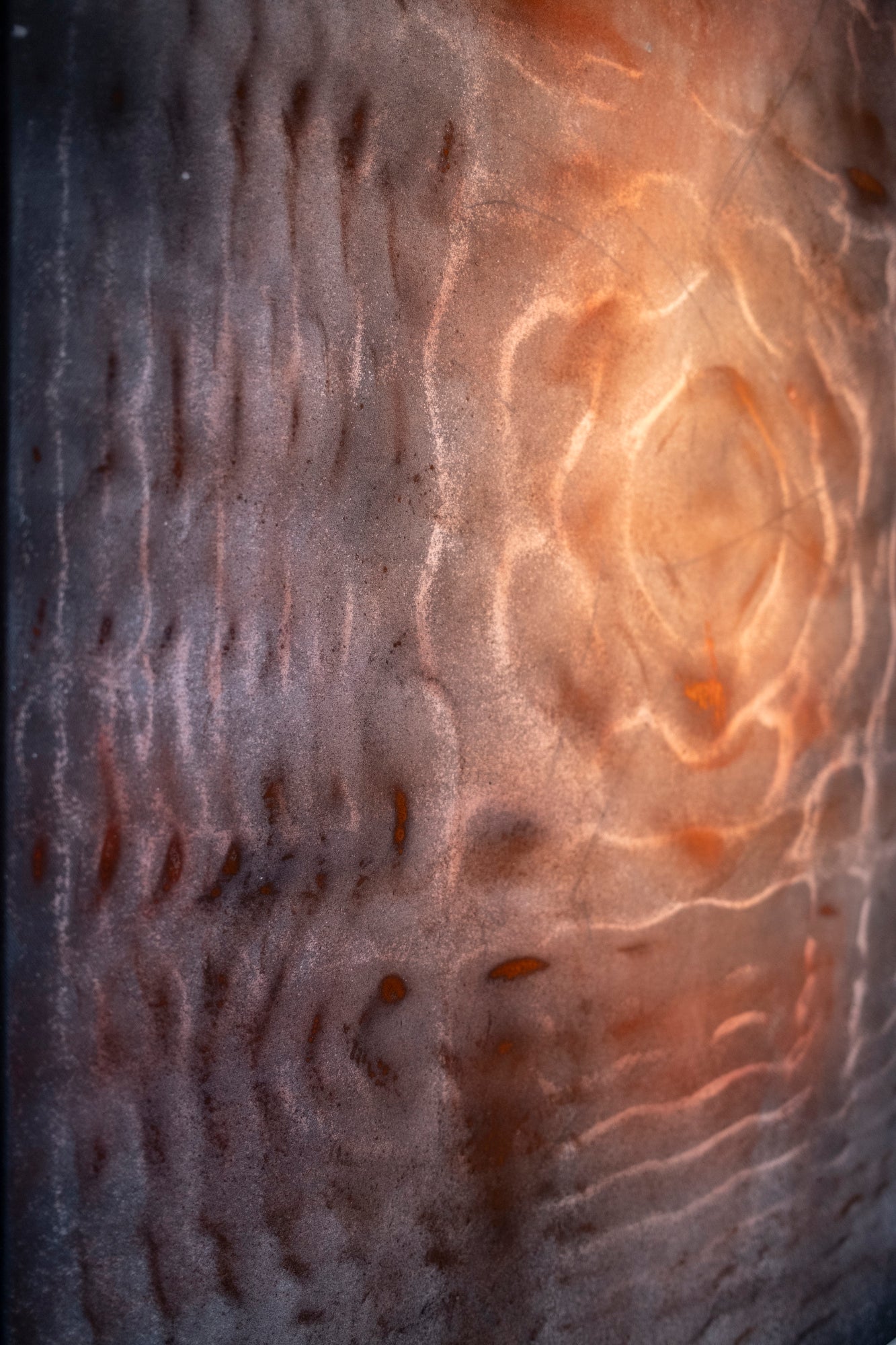 Close up detail of cymatics resonance painting showing earth pigment and charcoal patterns formed by sound