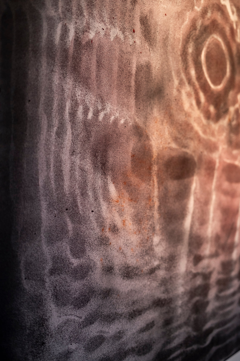 Close-up of a textured surface with circular patterns of sound made visible